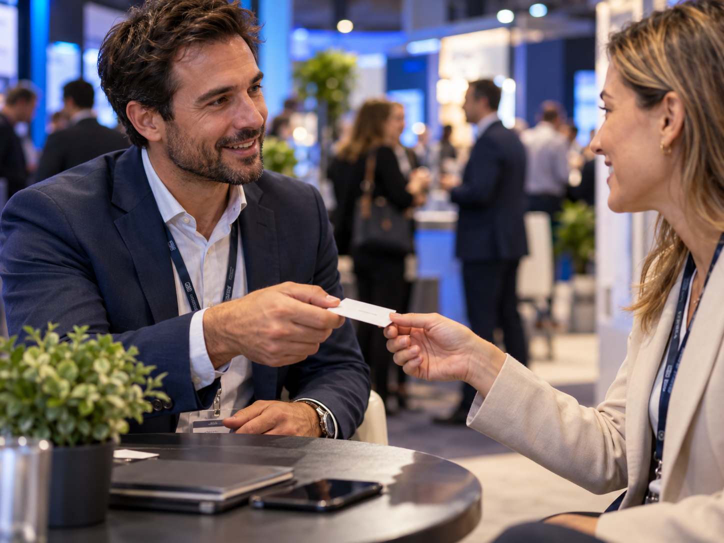 Two business representatives exchange a card at an expo